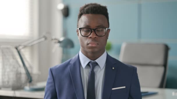 Portret poważnego afrykańskiego biznesmena patrzącego w kamerę  - Materiał filmowy, wideo