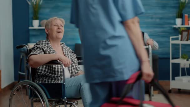 Medische assistent geeft ondersteuning aan oudere vrouw met invaliditeit - Video