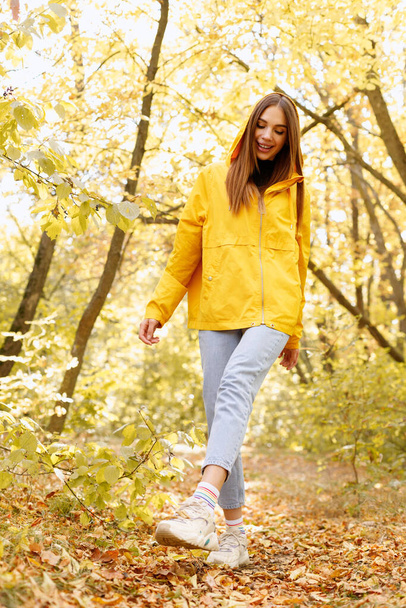 nainen hymyilee ja kävelee metsässä syksyllä - Valokuva, kuva