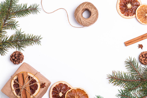 手作りクラフト紙ギフトボックス、乾燥柑橘類のスライス、シナモン、アニス、松のコーンとモミの木の枝、トップビューのコピースペースとクリスマス組成物 - 写真・画像