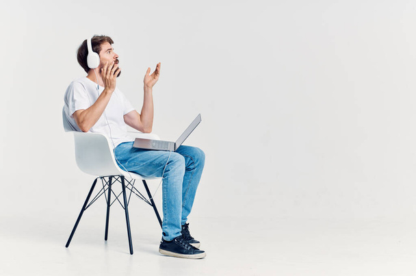 homem em t-shirt branca com laptop em fones de ouvido  - Foto, Imagem