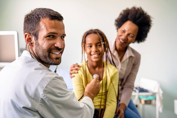 Male doctor examining a child patient in a hospital. Healthcare prevention people concept - Photo, Image