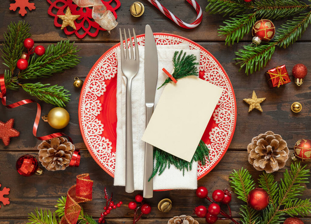 Juhlapöytä koristeilla, kuusen oksilla ja tyhjällä kortinäkymällä. Mockup joulun tai uudenvuoden kutsukortti tumma puinen pöytä tasainen lay, kopioi tilaa. Talvikausi, ravintola loma - Valokuva, kuva