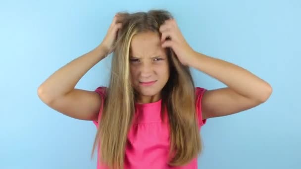 Dívka poškrábe hlavu na barevném pozadí - Záběry, video
