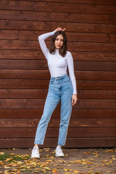 Full body portrait of a young beautiful brunette girl in blue jeans - Foto, Imagem
