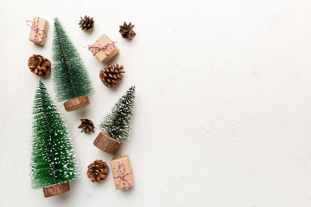 Flache Komposition mit Weihnachtsbäumen auf farbigem Hintergrund. Draufsicht mit Kopierraum. - Foto, Bild