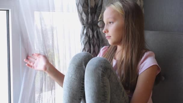 Een meisje in een slechte bui is alleen thuis bij het raam - Video