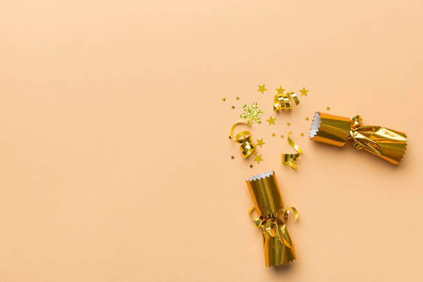 Christmas crackers with shiny confetti on color background, top view, copy space. - Photo, Image