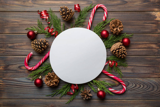 Flat lay Christmas composition. Round Paper blank, pine tree branches, christmas decorations on Colored background. Top view, copy space for text. - Valokuva, kuva