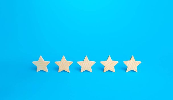 Five stars on a blue background. Rating evaluation concept. High satisfaction. Good reputation. Popularity rating of restaurants, hotels or mobile applications. Highest score. Service quality feedback - Valokuva, kuva