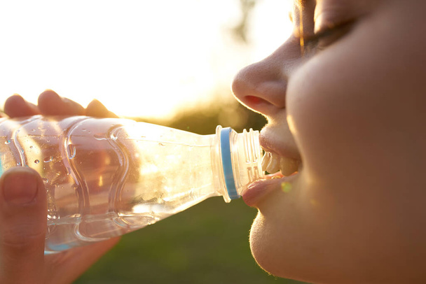 nő szabadban ivóvíz egy üveg - Fotó, kép