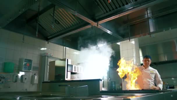 Cuoco professionista in cucina dà fuoco alla padella e friggere la carne. Padella bruciante - Filmati, video