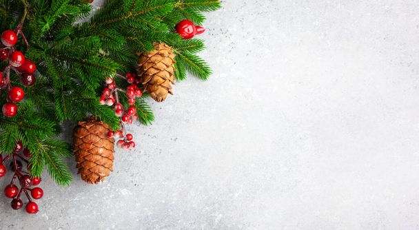 Weihnachten oder Neujahr Hintergrund mit grünen Tannenzweigen, roten Beeren und Zapfen. Winterkonzept, Draufsicht, Kopierraum - Foto, Bild