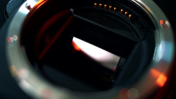 Close-up van de spiegel en matrix van een professionele camera. Close-up van de bajonetverbinding van een cameralens. Neon licht op fotocamera - Video