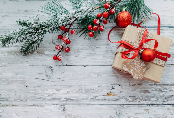 geschenkdoos en kerstversiering op een houten achtergrond met sneeuwvlokken. - Foto, afbeelding
