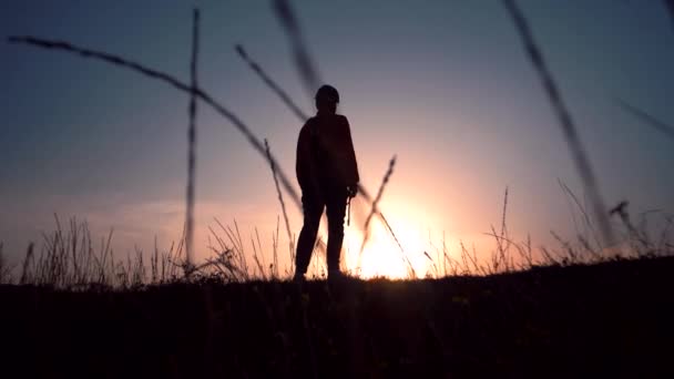Silhouette di un uomo che cade in ginocchio alla luce del tramonto - Filmati, video