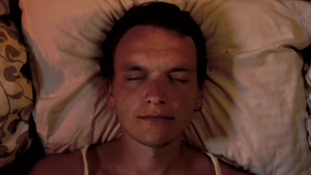 Jeune homme dort sur un oreiller, fait un cauchemar et se réveille - Séquence, vidéo