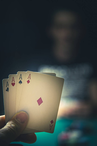 άνδρας κερδίζει στο πόκερ, δείχνοντας τους 4 άσσους στο χέρι του - Φωτογραφία, εικόνα