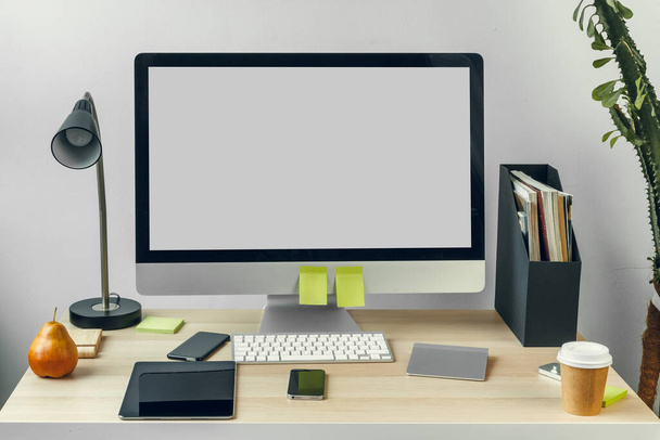Computer monitor with mockup white screen on office table with supplies - Zdjęcie, obraz