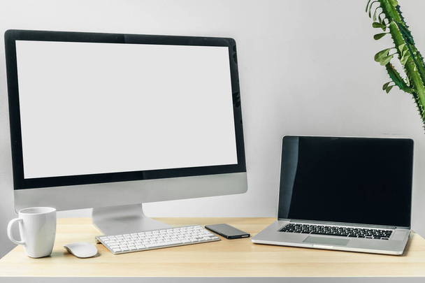 Computer monitor met mockup wit scherm op kantoor tafel met benodigdheden - Foto, afbeelding