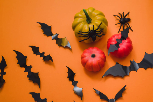 Fijne Halloween vakantie. Halloween decoraties, vleermuizen, spinnen, pompoenen op een oranje achtergrond. Vlakke lay, bovenaanzicht - Foto, afbeelding