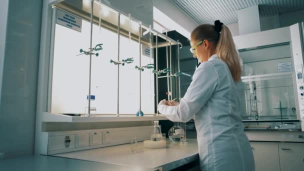 Un travailleur de laboratoire médical mélange des réactifs dans des éprouvettes - Séquence, vidéo