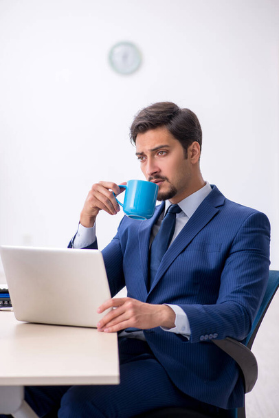 Young male employee drinking coffee during break - Фото, зображення