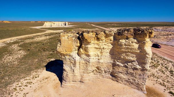 Velké pilíře bílých skal v ploché poušti s autem pro perspektivu - Fotografie, Obrázek