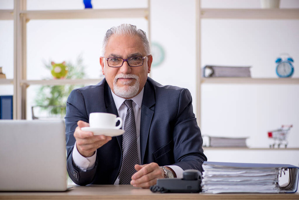 Старий чоловік п'є каву під час перерви
 - Фото, зображення