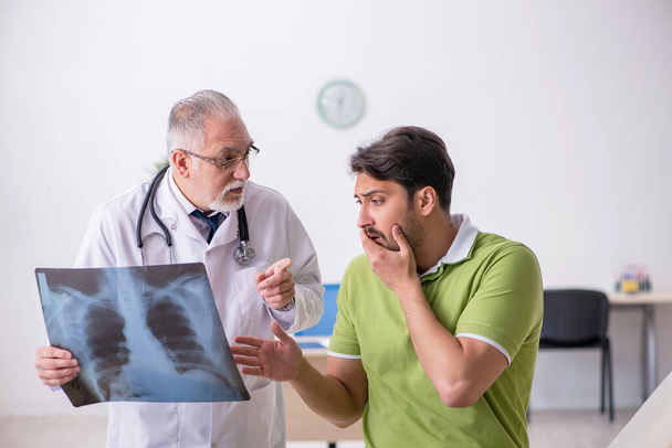 Fiatal férfi látogató öreg férfi orvos radiológus - Fotó, kép