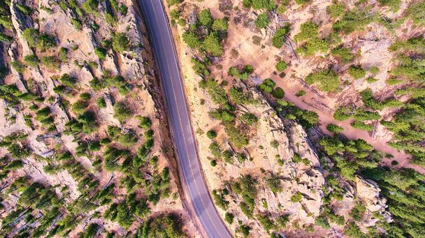 Vue aérienne en bas de la route à travers un paysage désertique rocheux - Photo, image