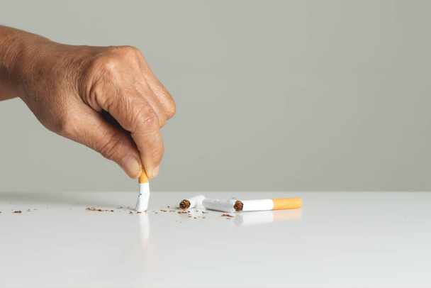 Leszokni a dohányzásról, nincs dohányzás nap, anyai kéz eltöri a cigarettát - Fotó, kép