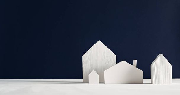 Malé bílé dřevěné domečky na černém pozadí. Minimalistický skandinávský dekorativní design - Fotografie, Obrázek