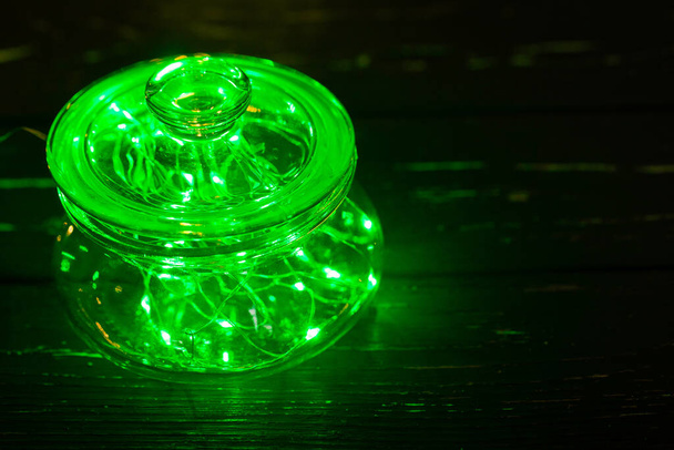 Green garland with light bulbs put in glass storage jar - Fotografie, Obrázek