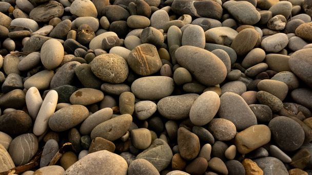 Fundo de pedras marinhas com pequenos seixos ou pedra no jardim ou à beira-mar ou em uma praia. Uma vista de perto de pedras de seixos polidas lisas arredondadas - Foto, Imagem