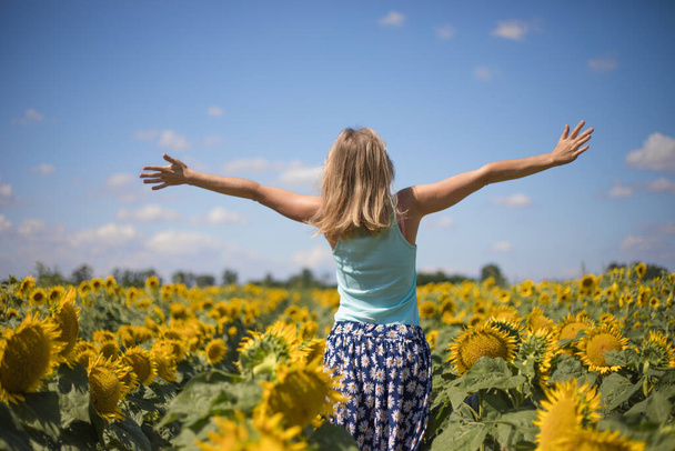 Beauty sunlit woman on yellow sunflower field Freedom and happiness concept. Happy girl outdoors - Photo, Image
