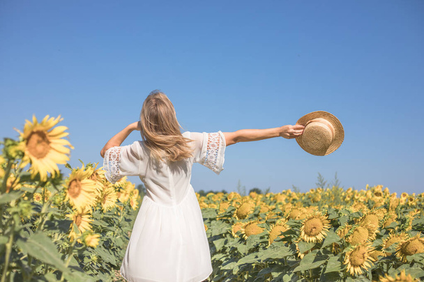 Sarı ayçiçeği tarlasında güneş ışığı saçan güzel kadın özgürlük ve mutluluk kavramı. Mutlu kız dışarıda - Fotoğraf, Görsel
