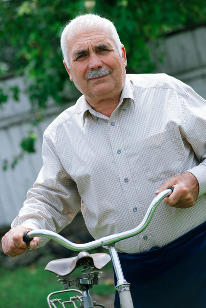 彼の自転車のハンドルバーに傾いたシニア男性 - 写真・画像