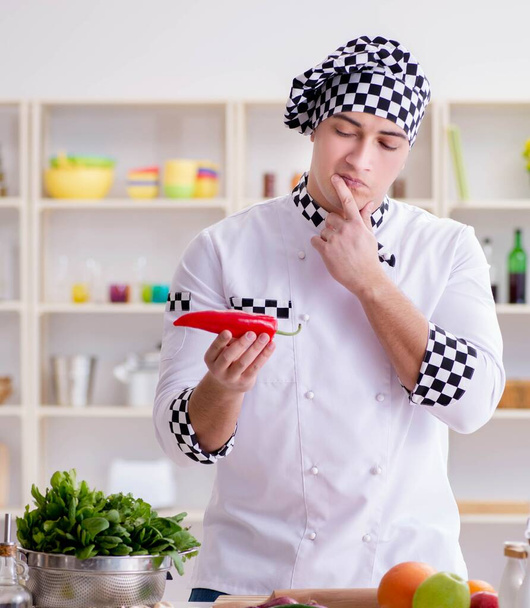 Молодой повар работает на кухне - Фото, изображение