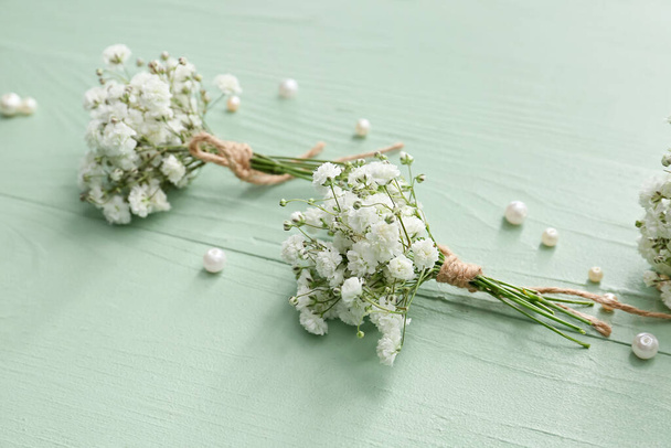 Beautiful gypsophila boutonnieres on color wooden background - Photo, Image
