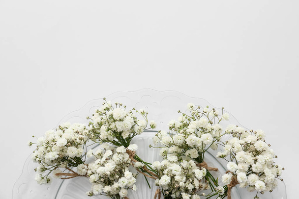 Beyaz arka planda güzel çingene yaka çiçekleri olan tabak, yakın plan. - Fotoğraf, Görsel