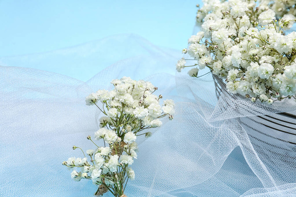 Beautiful gypsophila boutonnieres and bridal veil on color background, closeup - Photo, Image