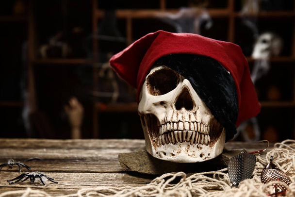 Pirate skull on table against dark background - Photo, Image