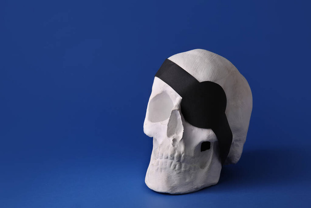 Cráneo pirata con parche en el ojo sobre fondo de color - Foto, imagen