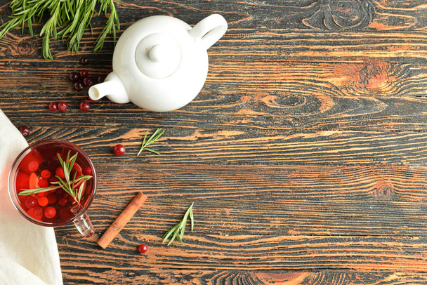 Skład z filiżanką smacznej herbaty żurawinowej i rozmarynu na drewnianym tle - Zdjęcie, obraz