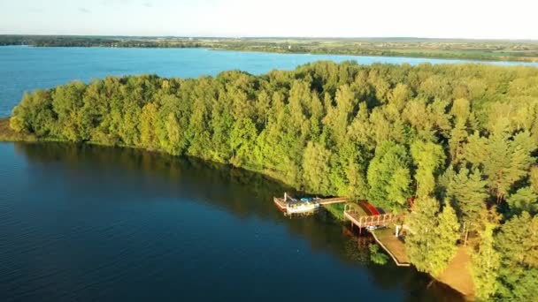 Bezirk Lyepyel, Gebiet Witebsk, Weißrussland. Luftaufnahme des Fischerstegs mit dem umliegenden Flusssee. Blick auf die Flussküste mit Wald im Sommer - Filmmaterial, Video