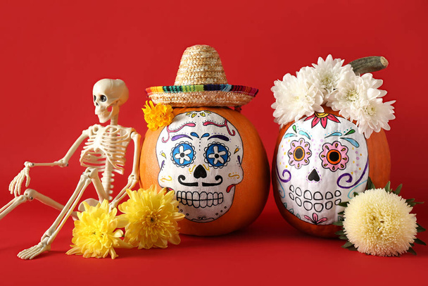 Тыквы с раскрашенным черепом на цветном фоне. Празднование Дня мертвых в Мексике (El Dia de Muertos) - Фото, изображение
