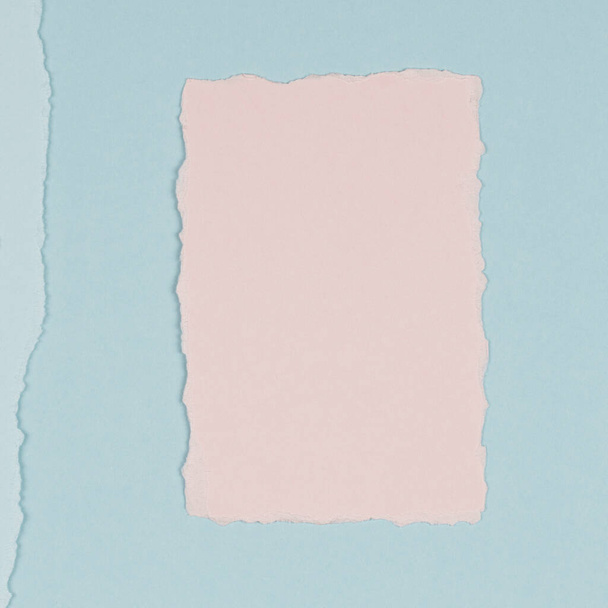 Zerrissenes Papier strukturierte Collage Hintergrund. Grunge-zerrissenes Pastell-Papierstück mit zerlumptem Rand auf hellblauem Papierhintergrund. - Foto, Bild