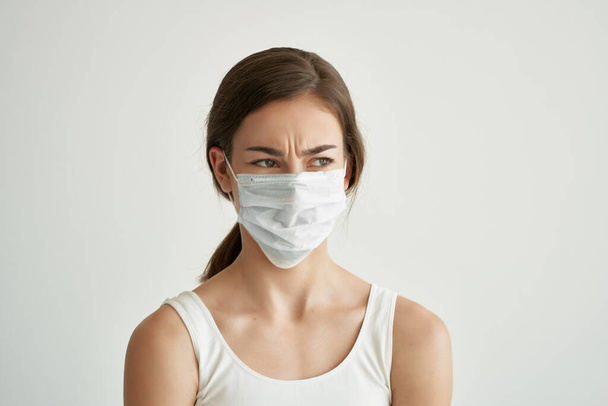 Nainen lääketieteellisessä naamiossa yllään valkoinen t-paita pandemiavirus - Valokuva, kuva