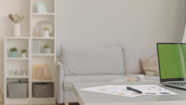 Schwenken keine Menschen aufgenommen von gemütlichen minimalistischen Home-Office-Interieur mit Laptop und Geschäftsunterlagen auf dem Schreibtisch - Filmmaterial, Video